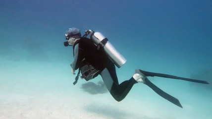 Man scuba diver on the blue water