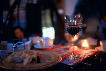 red wine glass serving / romantic dinner in the interior of the restaurant, a table served with a glass of grapes wine