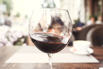 red wine splashing in a glass / glass with red wine in a cafe