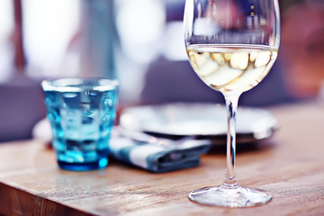 glass of white wine in the restaurant / white wine in the interior of the restaurant a table with glasses of wine, a romantic summer