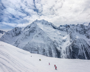 Fototapeta na wymiar Winter view of the Mussa-Achitara ski slope against Caucasus mountains Peak Ine, Dzhuguturlyuchat, Amanauz and Sofrudzhu. Dombai ski resort, Karachai-Cherkess, Russia.