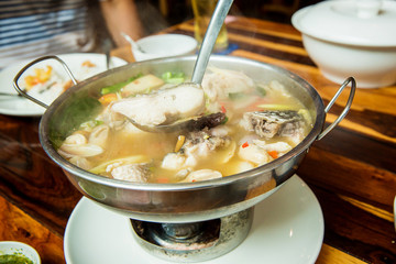 Thai spicy freshwater fish soup with herbs, served in big bowl. Tom Yam Pla. Thai famous street local food. recommended menu for tourist and traveler. image for background, wallpaper and menu list.