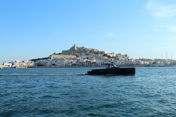 Fototapeta premium Black luzury yacht in Ibiza, Old Dalt Vila town in the background