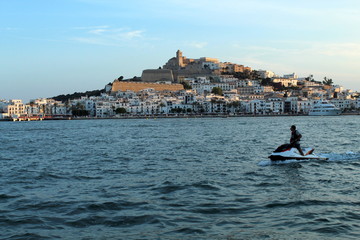 jetski in water and Ibiza old town Dalt Vila in the background