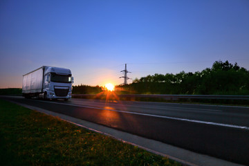 Fototapeta na wymiar Truck transportation on the road at sunset