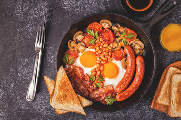 Traditional full English breakfast with fried eggs, sausages, beans, mushrooms, grilled tomatoes and bacon.