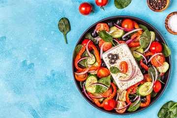 Greek salad of fresh cucumber, tomato, sweet pepper, spinach, red onion, feta cheese and olives