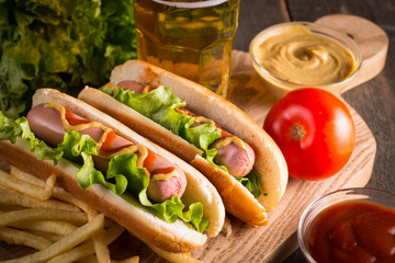 Photo of barbecue grilled hot dog with yellow mustard and ketchup on wooden background. Hot dog...