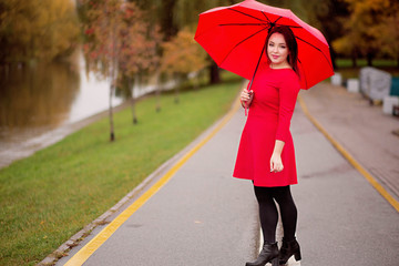 Obraz premium happy girl walks in the autumn park under an umbrella