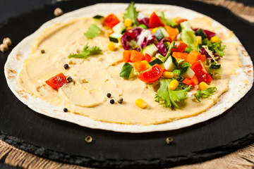Tortilla with vegetables and hummus with chickpeas.