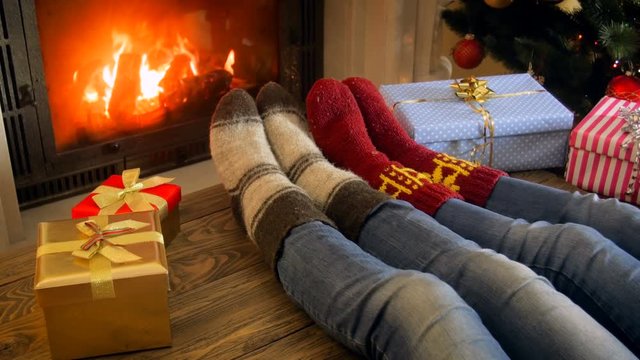 Closeup 4k footage of family wearing woolen socks relaxing by the fireplace on Christmas night