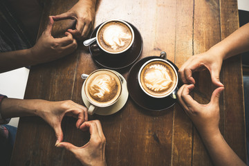 Fototapeta na wymiar Latte coffee art and people meeting friendship togetherness and show hand with love in coffee shop, Friends meeting happiness coffee shop concept