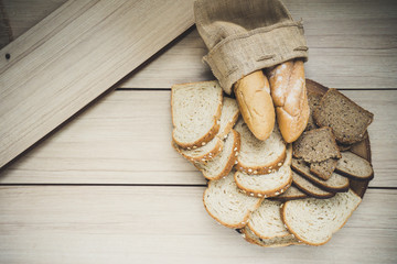 Fresh bread in burlap sack on wooden table. Top view with space for your text