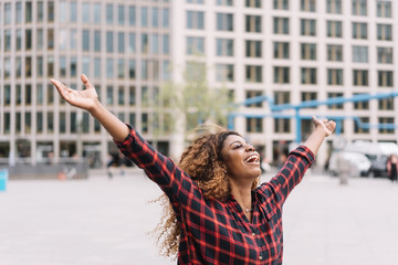 Joyful young woman celebrating with open arms