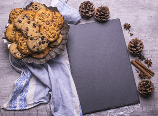 Delicious freshly baked Christmas cookies with black board for recipe on a gray wooden table.