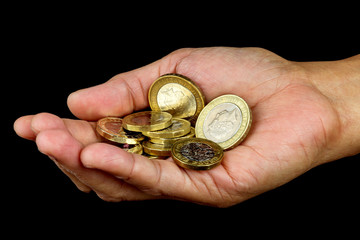 Open Hand Holding a Selection of Coins on Black Background