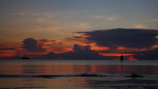 Girl athlete runs barefoot on the sea surface on the shore against a backdrop of a magnificent sunset. slowmotion, HD, 1920x1080
