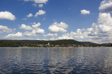 Heap clouds in the blue sky over the Titisee in the Black Forest