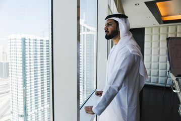 Arabic businessman looking out the window in his office