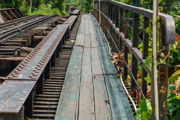 Fototapeta premium wooden sidewalk side of railway bridge over the canal in Thailand