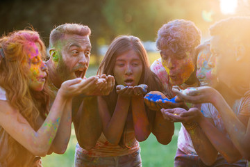 Fototapeta premium Group of teens playing with colors at the holi festival, in a park