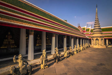 Bangkok - October 14, 2014: Ancient stone statues of men in Wat Arun, the Temple of Dawn, in Bangkok, Thailand