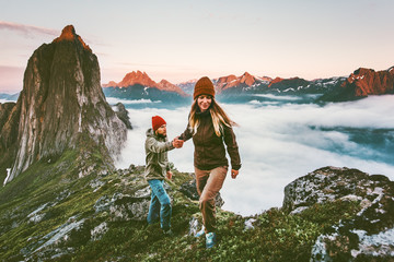 Happy Couple holding hands traveling together hiking in Norway healthy lifestyle concept active...