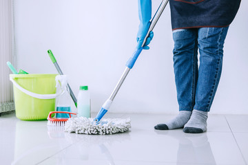 Housekeeping and cleaning concept, Happy young woman in blue rubber gloves wiping dust using mop...