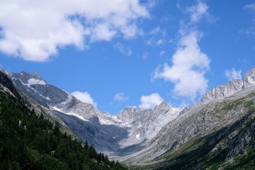 Fototapeta na wymiar paesaggio montagna natura cielo azzurro nuvole cime rocce parco all'aperto neve