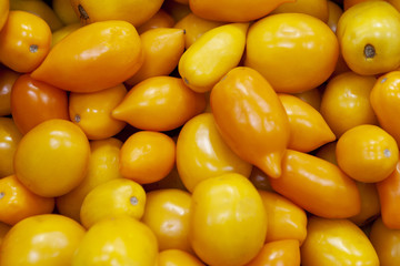 Heap of fresh ripe orange tomatoes without branches.