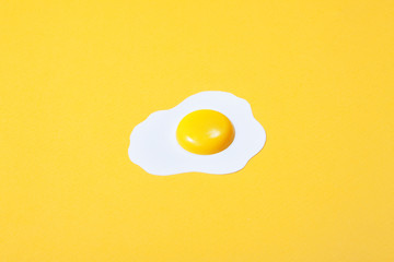 one paper fried egg, set against a backdrop of yellow paper.