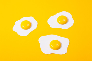 three paper scrambled eggs-fried eggs located on a yellow paper background.