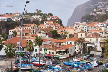 View of Câmara de Lobos in Madeira with Cape Girão on the background and boats at the marina