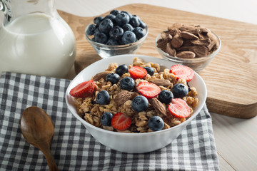 Healthy breakfast concept with oat flakes and fresh berries on rustic background. Food made of granola and muesli. Healthy banana smoothie with blackberries, honey and milk.