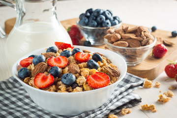 Healthy breakfast concept with oat flakes and fresh berries on rustic background. Food made of granola and muesli. Healthy banana smoothie with blackberries, honey and milk.