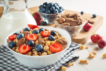 Healthy breakfast concept with oat flakes and fresh berries on rustic background. Food made of granola and muesli. Healthy banana smoothie with blackberries, honey and milk.