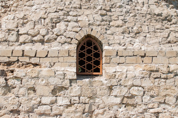 Naklejka premium A stone wall with a small window.