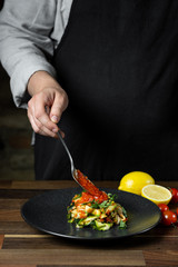 Chef cooking zucchini Italian dish cooking with cheese and tomato sauce, steps on black background kitchen.