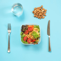 Vegetables healhy salad for office lunch in container on blue table. Concept proper nutrition. Lunchbox. Take away.