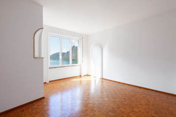 White room with large windows overlooking the lake