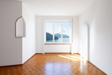 White room with large windows overlooking the lake