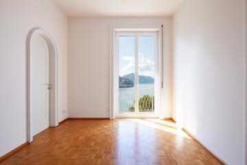 White room with large windows overlooking the lake
