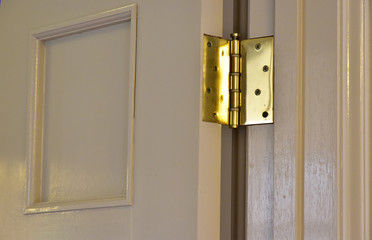 Scene of the wooden door of the room and the golden hinge
