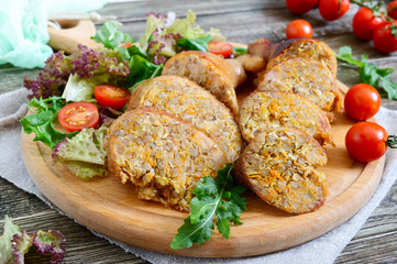 Tasty stuffed chicken legs with salad of fresh vegetables on a wooden background. Rolls with chicken and vegetables.