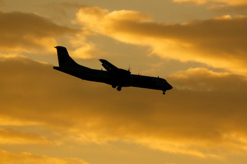 Airplane in the rays of sunset as a background