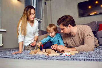 A family with a child plays board games indoors.