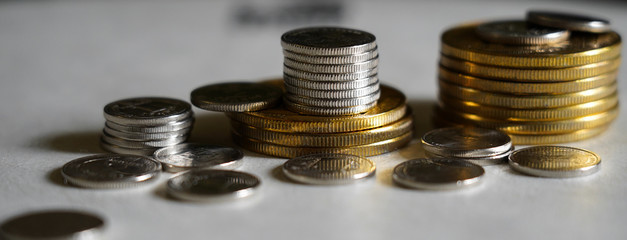 Macro shot detail of golden and silver color coin stacks on dark background with copy space for text. Business and finance growth, saving money, investment and interest concept.