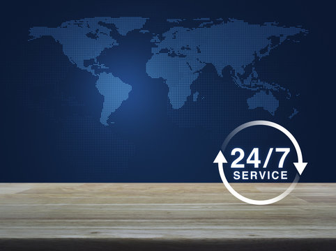 24/7 service flat icon on wooden table over digital world map blue tone background, Full time service concept, Elements of this image furnished by NASA