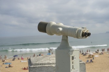 Coin operated binocular on the summer beach, tourist scene in Spain