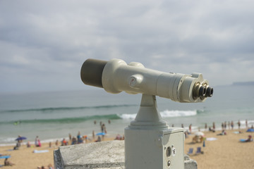 Coin operated binocular on the summer beach, tourist scene in Spain